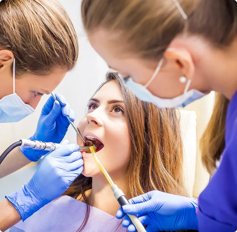 Dentists performing dental examination on patient during treatment procedure